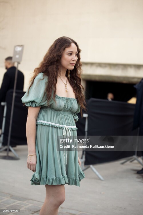 PARIS, FRANCE - MARCH 06: Laufey wears a short green mini dress with a white bow outside the Chloe fashion show during the Womenswear Fall/Winter 2025/2026 as part of Paris Fashion Week on March 06, 2025 in Paris, France. (Photo by Raimonda Kulikauskiene/Getty Images)