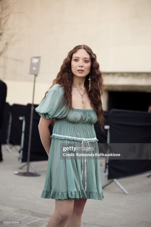 PARIS, FRANCE - MARCH 06: Laufey wears a short green mini dress with a white bow outside the Chloe fashion show during the Womenswear Fall/Winter 2025/2026 as part of Paris Fashion Week on March 06, 2025 in Paris, France. (Photo by Raimonda Kulikauskiene/Getty Images)