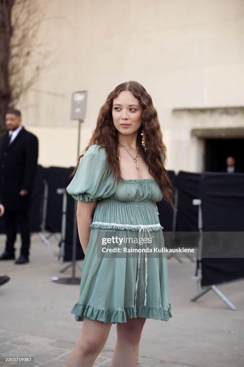 PARIS, FRANCE - MARCH 06: Laufey wears a short green mini dress with a white bow outside the Chloe fashion show during the Womenswear Fall/Winter 2025/2026 as part of Paris Fashion Week on March 06, 2025 in Paris, France. (Photo by Raimonda Kulikauskiene/Getty Images)