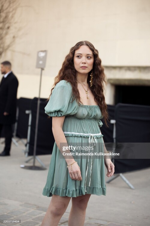 PARIS, FRANCE - MARCH 06: Laufey wears a short green mini dress with a white bow outside the Chloe fashion show during the Womenswear Fall/Winter 2025/2026 as part of Paris Fashion Week on March 06, 2025 in Paris, France. (Photo by Raimonda Kulikauskiene/Getty Images)