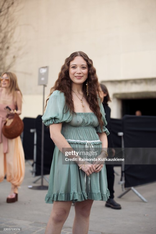 PARIS, FRANCE - MARCH 06: Laufey wears a short green mini dress with a white bow outside the Chloe fashion show during the Womenswear Fall/Winter 2025/2026 as part of Paris Fashion Week on March 06, 2025 in Paris, France. (Photo by Raimonda Kulikauskiene/Getty Images)
