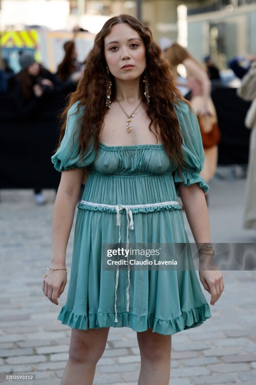PARIS, FRANCE - MARCH 06: Laufey wears teal ruffled mini skirt, gold and pear earrings and necklace, outside Chlo?, during the Womenswear Fall/Winter 2025/2026 as part of Paris Fashion Week on March 06, 2025 in Paris, France. (Photo by Claudio Lavenia/Getty Images)