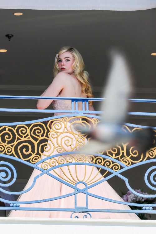 Elle Fanning is seen at the Martinez hotel during the 75th annual Cannes Film Festival on May 18, 2022 in Cannes, France. She wearing a white dress at Martinez balcony.