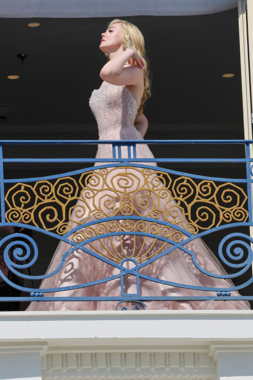 Elle Fanning is seen at the Martinez hotel during the 75th annual Cannes Film Festival on May 18, 2022 in Cannes, France. She wearing a white dress at Martinez balcony.