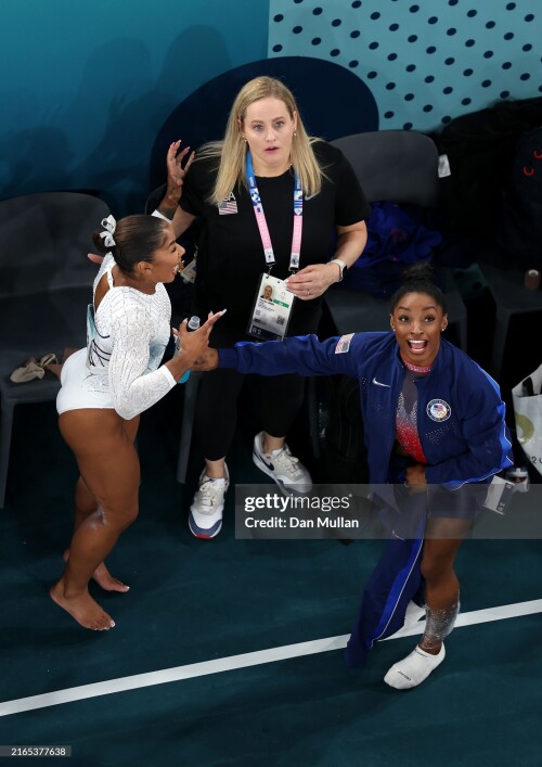 PARIS, FRANCE - AUGUST 05: (EDITORS NOTE: Image was captured using a robotic camera positioned above the field of play.)  Simone Biles and Jordan Chiles of Team United States celebrate winning the silver and bronze medals respectively after competing in the Artistic Gymnastics Women's Floor Exercise Final on day ten of the Olympic Games Paris 2024 at Bercy Arena on August 05, 2024 in Paris, France. (Photo by Dan Mullan/Getty Images)