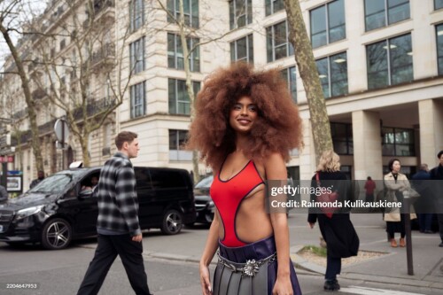 PARIS, FRANCE - MARCH 11: Paola Locatelli wears grey pleated skirt, red cut out top and black bag from Miu Miu outside the Miu Miu fashion show during the Womenswear Fall/Winter 2025/2026 as part of Paris Fashion Week on March 11, 2025 in Paris, France. (Photo by Raimonda Kulikauskiene/Getty Images)